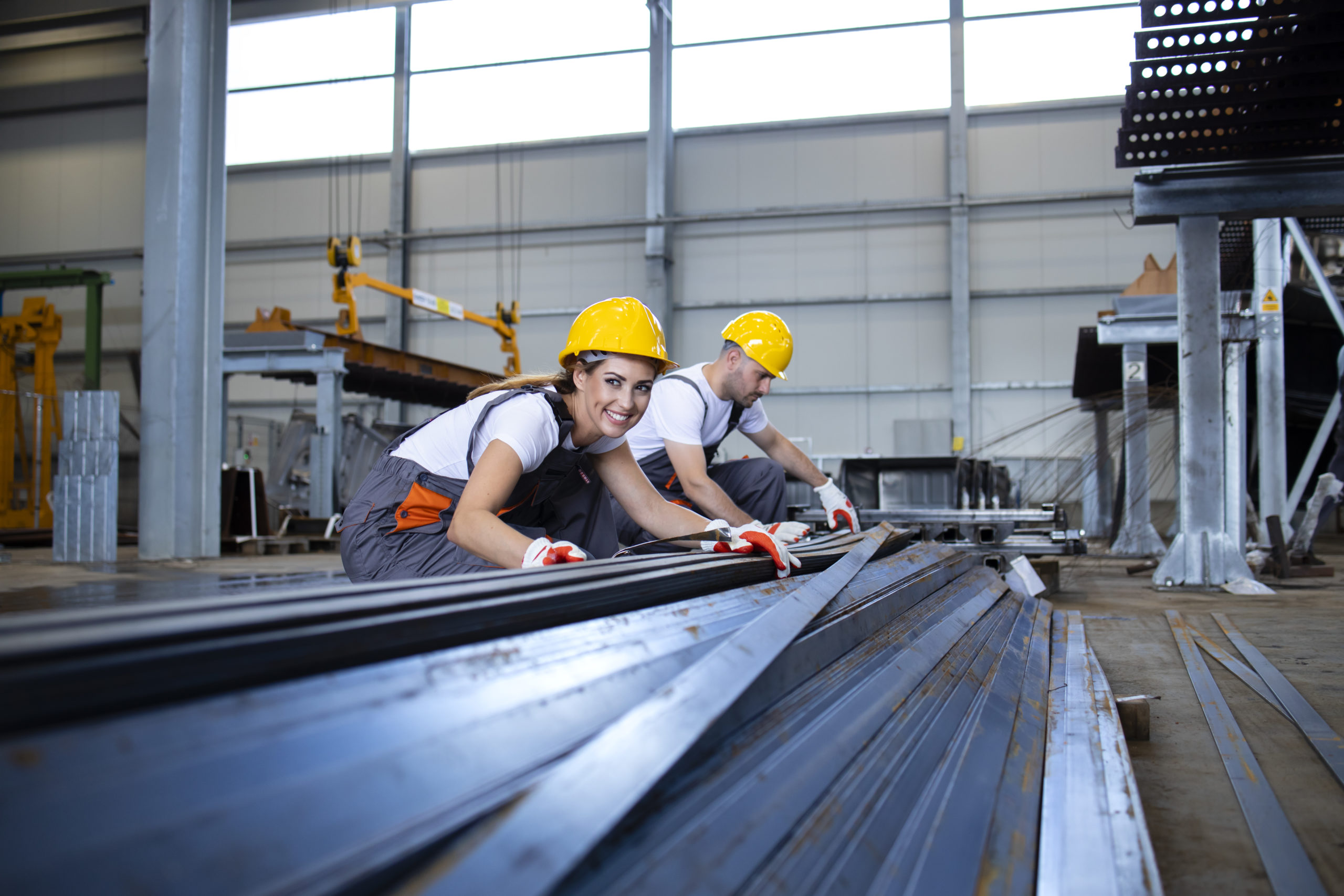 Industrial workers working in factory hall with metal. Providing shelter and comfort
